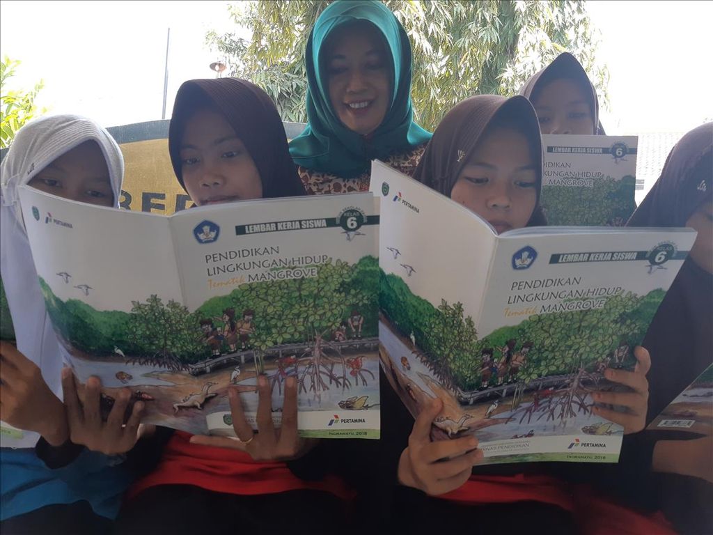 Kepala SDN Paoman IV Lutfiya bersama siswa membaca buku terkait mangrove di sekolah di Kabupaten Indramayu, Jawa Barat, Sabtu (25/5/2019). SDN Paoman IV termasuk dalam 26 SD di Indramayu yang menerapkan kurikulum pendidikan lingkungan hidup tematik mangrove. Tahun ini, ditargetkan 42 SD menerapkan hal serupa.
