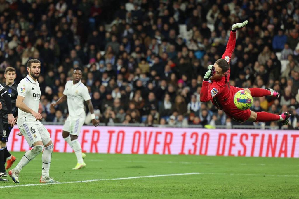 Pemain Real Madrid Spanish Nacho Fernandez (kiri) hanya bisa terpana saat kiper Real Sociedad Alex Remiro melompat untuk menyelamatkan gawangnya pada laga Liga Spanyol di Stadion Santiago Bernabeu, Madrid, Minggu (29/1/2023). Laga berakhir imbang 0-0. 