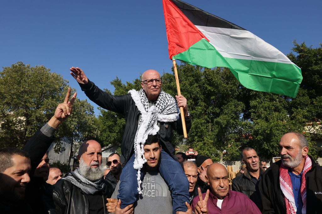 Warga Israel keturunan Arab, Karim Younes, membawa bendera Palestina usai dibebaskan setelah menjalani masa tahanan dari sebuah penjara Israel, di Kota Ara, Kamis (5/1/2023). 