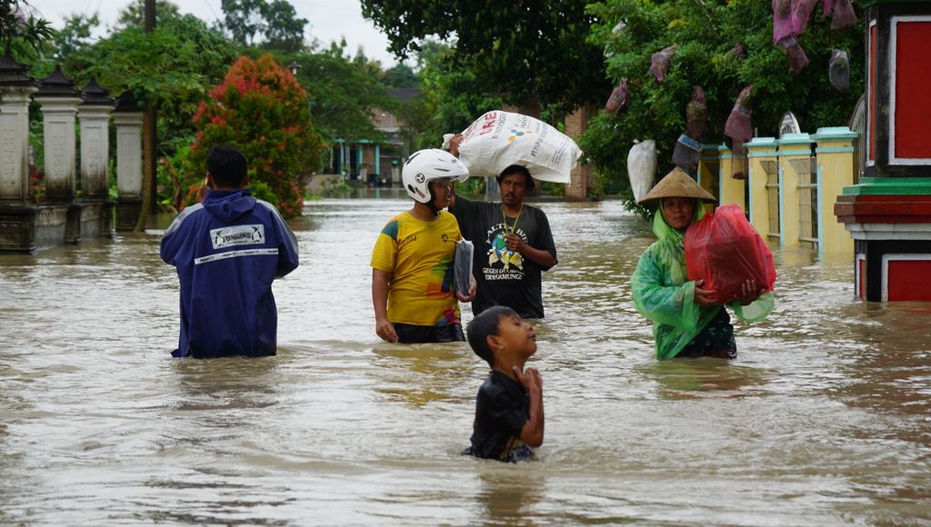 Sejumlah warga tengah mengevakuasi diri akibat banjir yang melanda di Desa Tangkil, Kecamatan Sragen, Kabupaten Sragen, Jawa Tengah, Kamis (2/3/2023). Banjir terjadi sejak Rabu malam. Namun, ketinggiannya meningkat mengingat hujan juga tidak kunjung reda.