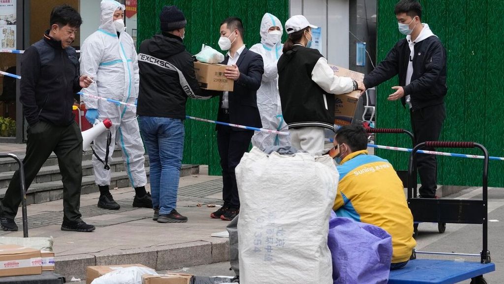 Pekerja mengumpulkan makanan dan barang yang dikirimkan untuk komunitas warga yang wilayahnya sedang diberlakukan penguncian di Beijing, China, Minggu (13/3/2022). 