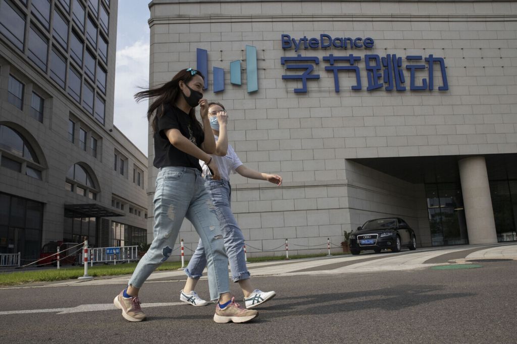 Dalam foto yang diambil pada 7 Agustus 2020 ini tampak warga Beijing tengah berjalan melintas di depan Markas Besar ByteDance yang terletak di Beijing, China.
