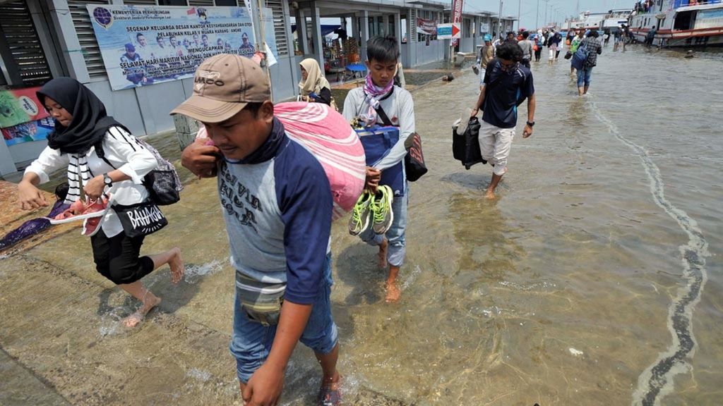 Banjir rob setinggi 10-15 cm menggenangi dermaga Kali Adem, Muara Angke, Jakarta Utara, Rabu (3/1/2018). Meski terendam banjir rob, pelayanan bagi masyarakat dari dan menuju Kepulauan Seribu tetap berjalan normal.
