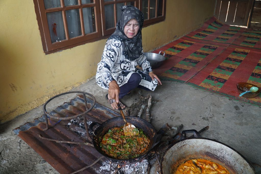 Jusdahniar (57) memasak rendang daun di rumahnya di Nagari Batu Bulek, Kecamatan Lintau Buo Utara, Tanah Datar, Sumatera Barat, Sabtu (28/5/2022). Rendang khas Lintau ini menggunakan bahan-bahan 50-an hingga 100-an jenis dedaunan dan belut sawah.