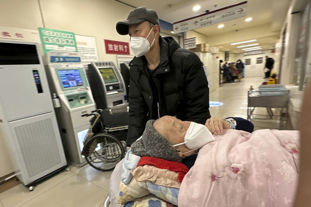 Seorang pasien lanjut usia didorong di koridor bangsal darurat di sebuah rumah sakit di Beijing, China, Sabtu (31/12/2022). Pelonggaran dan pencabutan protokol kesehatan yang ketat secara mendadak membuat rumah sakit dibanjiri pasien Covid-19 yang mengeluhkan demam. 