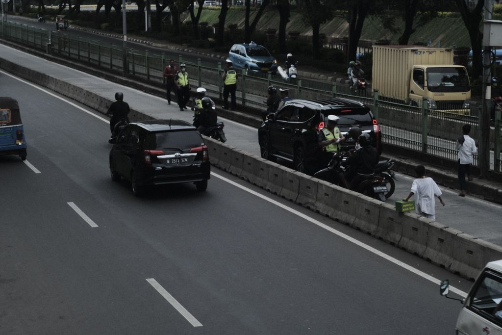 Polisi menilang sejumlah kendaraan di Jalan Sultan Agung, Setiabudi, Jakarta Selatan, Jumat (31/1/2020), karena menerobos jalur busway.