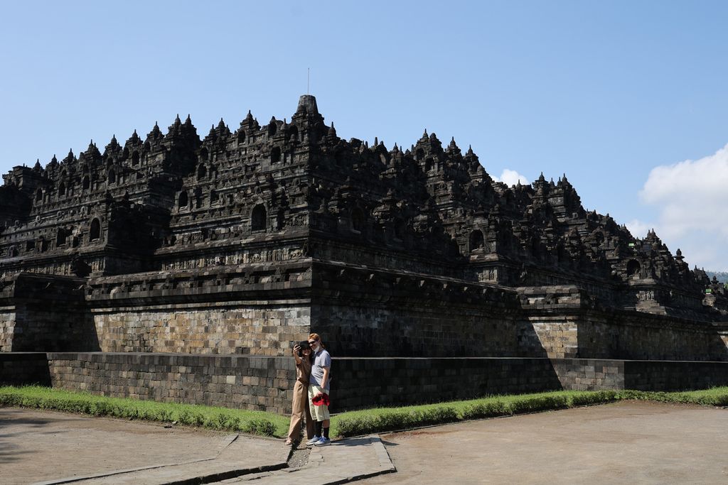 Wisatawan mengelilingi Candi Borobudur, Magelang, Jawa Tengah, Rabu (22/6/2022). Peraturan yang melarang pengunjung menaiki candi masih diberlakukan untuk mengurangi dampak kerusakan pada batuan candi tersebut.