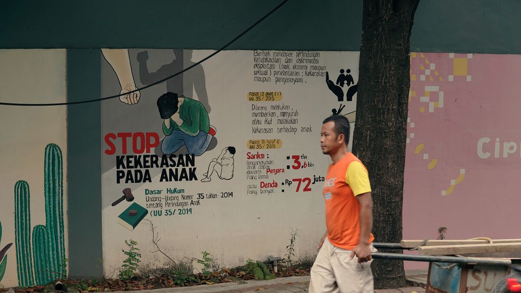 Warga melintasi mural hentikan kekerasan pada anak di Pulo Gadung, Jakarta Timur, Kamis (17/3/2022). 