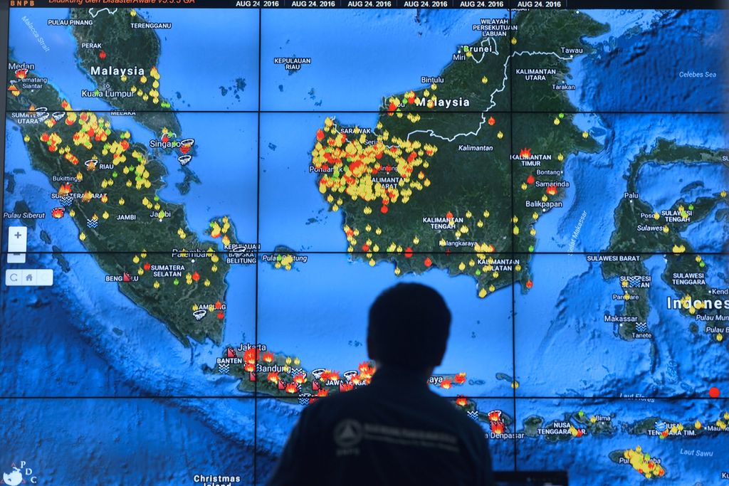 Citra satelit yang menunjukkan titik api yang membakar hutan atau lahan selama satu pekan terakhir di wilayah Indonesia dipantau dari ruang Pusat Pengendalian Operasi Badan Nasional Penanggulangan Bencana, Jakarta.