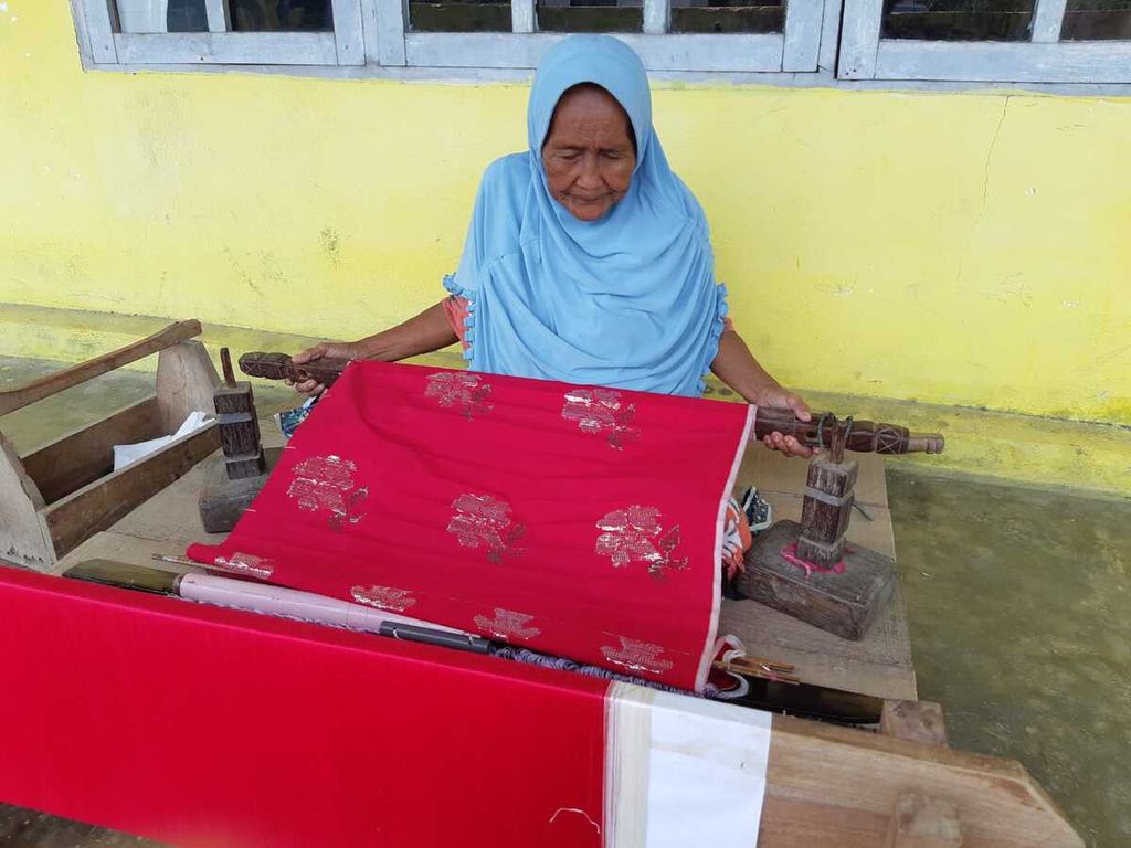 Sauna (77), artisan tenun senior sarung Donggala, menenun di teras depan rumahnya di Desa Towale, Kecamatan Banawa Tengah, Kabupaten Donggala, Sulawesi Tengah, Jumat (10/2/2023).