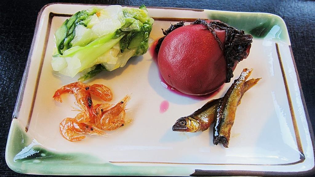 Pendamping hidangan utama berupa sayuran, acar buah plum (ume), udang kering, dan ikan manis.
