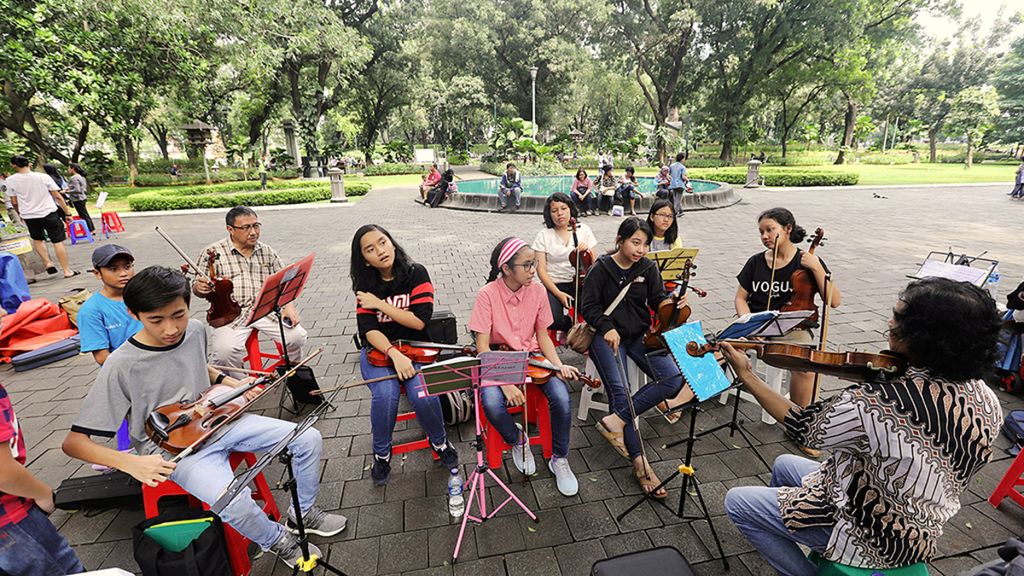 Sejumlah anggota komunitas berlatih memainkan biola di Taman Suropati, Menteng, Jakarta Pusat, Minggu (18/2). Taman kota yang nyaman tidak hanya menjadi paru-paru di tengah belantara beton Ibu Kota, tetapi juga dapat menjadi ruang bagi warga yang ingin melepaskan diri dari keruwetan kota, bersantai, sekaligus bersosialisasi.