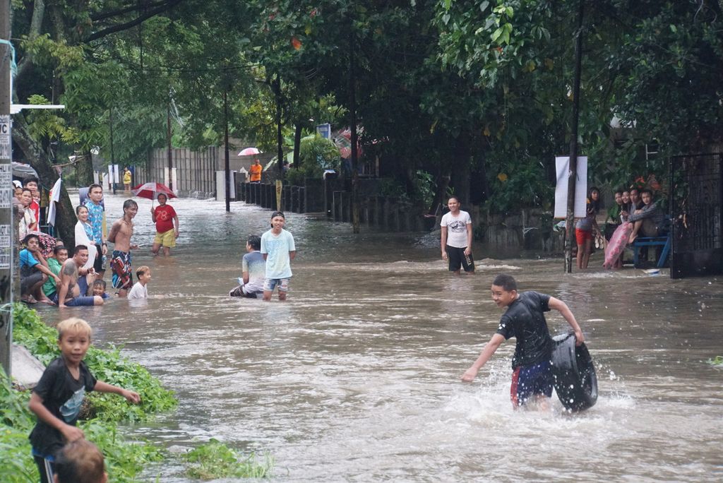 Banjir menggenangi akses jalan dari wilayah Karombasan Utara menuju Ranotana, Manado, Sulawesi Uatra, setelah hujan deras mengguyur kota, Sabtu (16/1/2021). Banjir memutus akses transportasi dan menyebabkan listrik padam di sejumlah daerah di Manado.