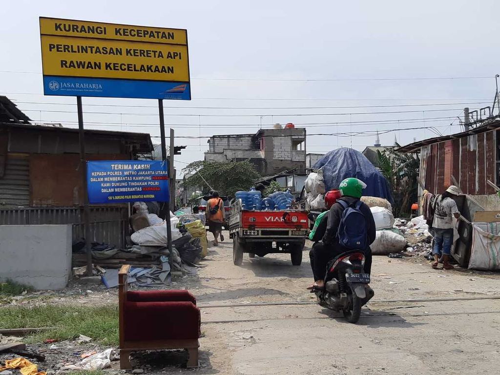 Warga melintasi di pelintasan sebidang di Kampung Bahari, Tanjung Priok, Jakarta Utara, Rabu (16/3/2022) siang.