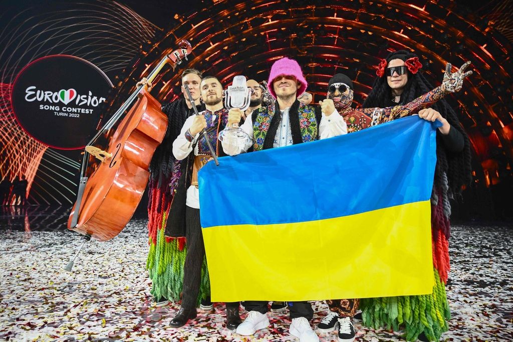 "Kalush Orchestra" merayakan kemenangannya di atas panggung dengan mengibarkan bendera Ukraina dan mengangkat piala. Band yang mewakili Ukraina itu memenangi kontes Eurovision Song 2022 pada 14 Mei 2022 di Pala Alpitour di Turin, Italia.(Photo by Marco BERTORELLO / AFP)