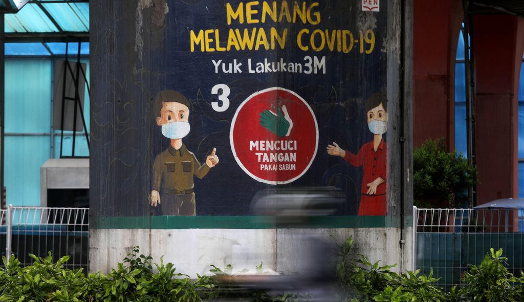 Pengendara melintas di depan mural tentang waspada Covid-19 di kawasan Sunter, Jakarta Utara, Kamis (9/2/2023).