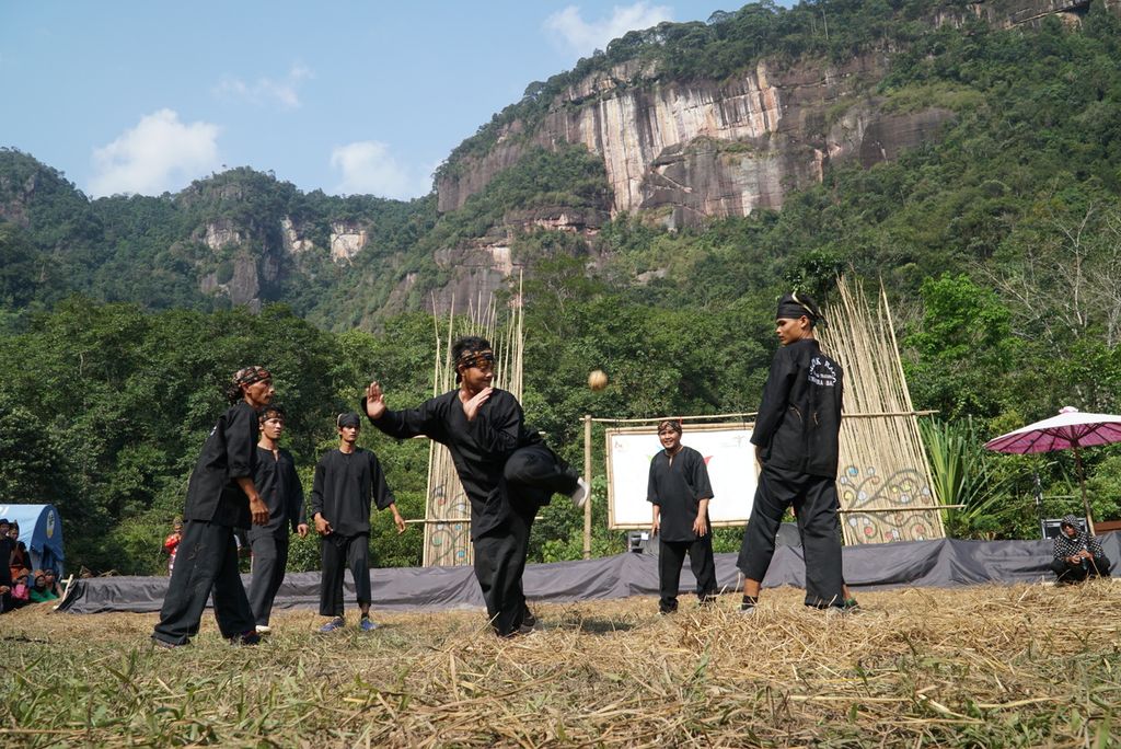 Seorang pemain <i>sipak rago</i> menyepak bola tanpa melihat dalam Festival Seni dan Budaya Pasa Harau di Lembah Harau, Limapuluh Kota, Sumatera Barat, Minggu (18/8/2019). Dalam olahraga tradisional yang mirip dengan sepak takraw ini, para pemain saling mengoper bola di udara.