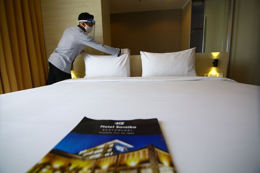 Karyawan Hotel Santika Banyuwangi dengan mengenakan masker, sarung tangan, dan <i>face shield</i> ketika merapikan kamar yang akan digunakan tamu hotel di Banyuwangi, Jumat (12/6/2020). Dalam masa persiapan menuju normal baru, pelayanan hotel mengedepankan fasilitas yang higienis, bersih, sehat, dan nyaman.