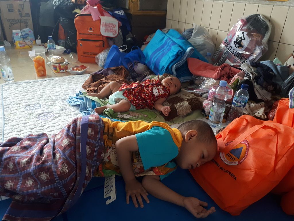 Bayi berusia 3 bulan dan anak berusia empat tahun yang tertidur di pengungsian Masjid Al Aqwam, Pela Mampang, Mampang Prapatan, Kamis (29/12/2022).