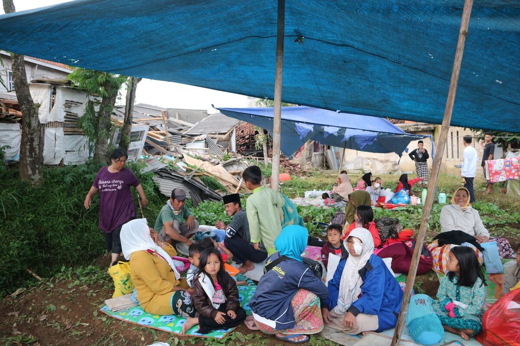 Warga RT 03 RW 03 Desa Cibeureum, Cugenang, Cianjur, Jawa Barat, mengungsi di salah satu tenda darurat akibat rumah mereka terdampak gempa, Senin (21/11/2022). Gempa tektonik berkekuatan magnitudo 5,6 merusak sejumlah permukiman masyarakat di sekitar Cianjur.