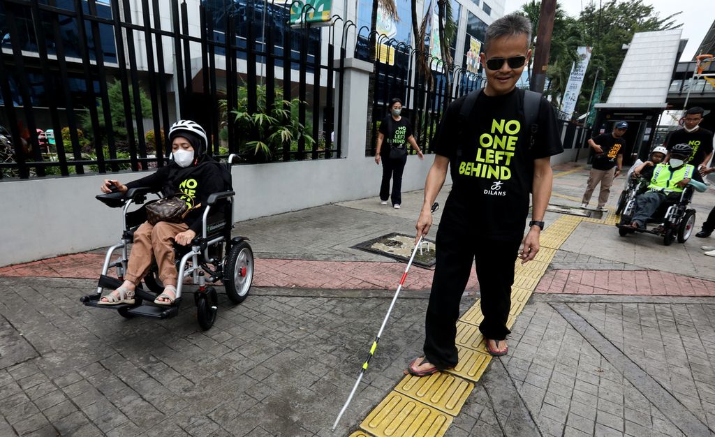 Sejumlah anggota gerakan penyandang Disabilitas dan Lanjut Usia (Dilans) Indonesia melintas di trotoar Jalan Sisingamangaraja, Jakarta Selatan, saat memperingati Hari Kursi Roda Internasional 2023, Rabu (1/3/2023). 