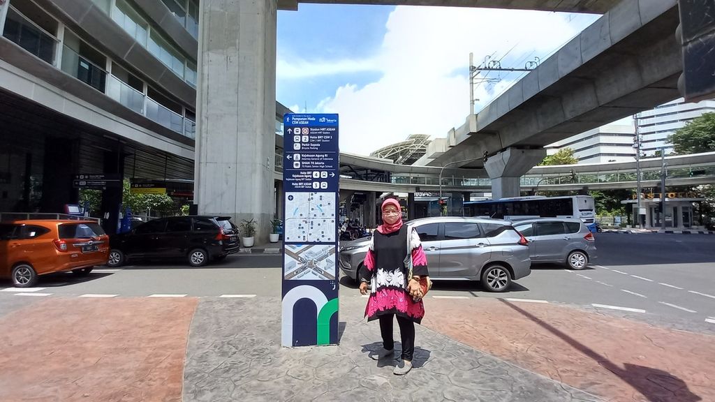 Endang (73) berdiri di depan papan penunjuk moda angkutan umum di bawah halte CSW, Jakarta Selatan pada Kamis (27/1/2022). Pensiunan bankir ini memiliki hobi untuk berkeliling Jakarta menggunakan angkutan umum.