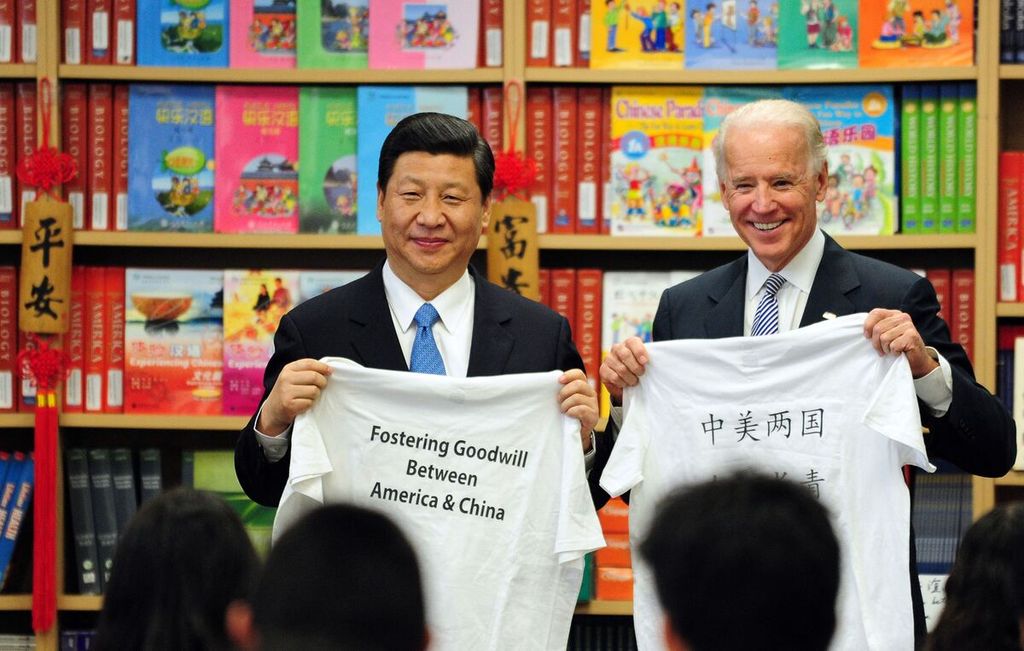 Wakil Presiden China Xi Jinping dan Wakil Presiden Amerika Serikat Joe Biden memamerkan baju kaos bertulis pesan-pesan positif dari para siswa Sekolah Kajian Hubungan Internasional Southgate di Los Angeles, California pada tanggal 17 Februari 2012. Xi menjadi presiden China sejak tahun 2013 dan Biden menjadi presiden AS sejak 2021.       