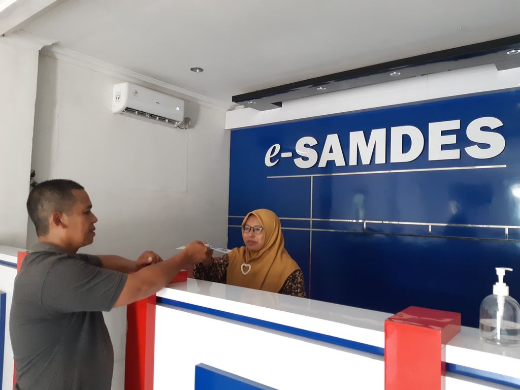 An official from the Village-Owned Enterprise (BUMDes) in Kampung Bandar Agung, Terusan Nunyai District, Central Lampung Regency, Lampung, serving residents who wish to pay motor vehicle taxes through the village samsat electronic service or e-Samdes, on Tuesday (14/3/2023) . Currently, there are 477 BUMDes that are e-Samdes agents.