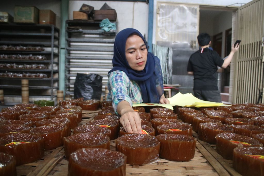Salah satu pekerja memasang label kue keranjang di pabrik kue keranjang Tek Kie, Jalan Pajagalan, Kecamatan Astanaanyar, Kota Bandung, Jawa Barat, Selasa (17/1/2023). Kue ini kerap ditemui dalam perayaan Imlek.