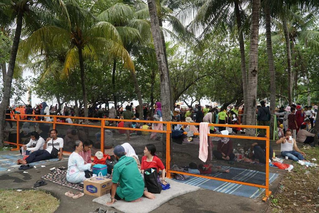 Wisatawan berekreasi di kawasan Pantai Lagoon Ancol, Taman Impian Jaya Ancol, Jakarta Utara, pada hari kedua Idul Fitri 1443 Hijriah, Selasa (3/5/2022). Pengelola menargetkan rata-rata 55.000 wisatawan berkunjung per hari saat momen libur Lebaran pada 2-15 Mei 2022.
