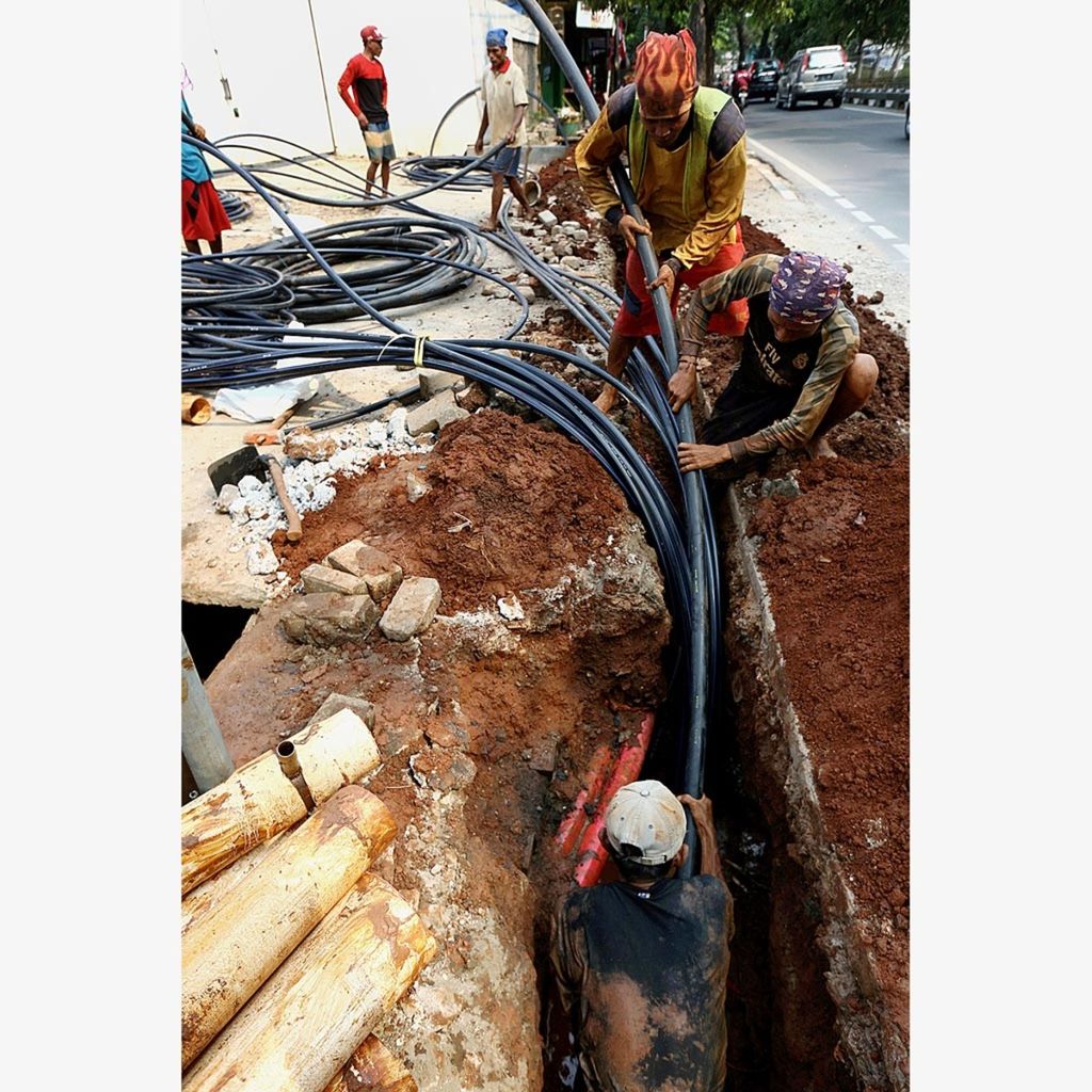Workers laying internet network cable sheaths in Jalan Panjang, West Jakarta, Thursday (23/8/2018).  According to a survey conducted by the Indonesian Internet Service Providers Association (APJII), the number of Internet users in Indonesia in 2017 was 143.26 million.
