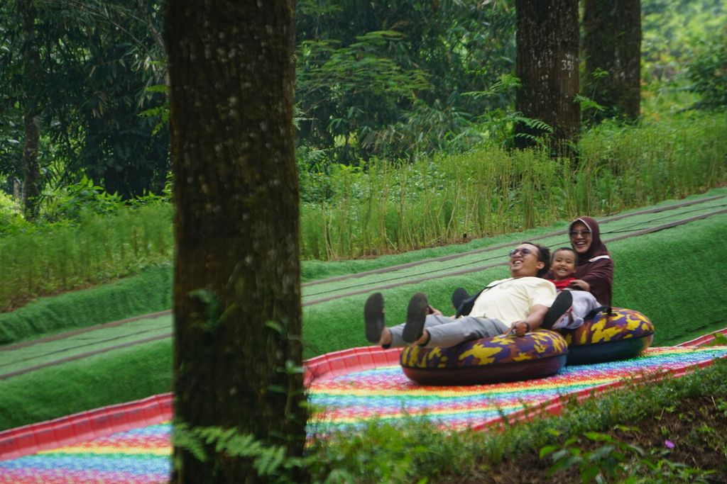 Pengunjung bermain<i> mountain slide</i> di Hutan Pinus Limpakuwus, Baturraden, Banyumas, Jawa Tengah, Rabu (14/12/2022).