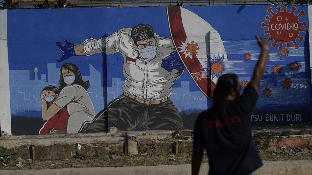 Warga melintasi mural ajakan bersama-sama melawan Covid-19 di kawasan Bukit Duri, Jakarta Selatan, Selasa (1/9/2020). Penanganan pandemi akan tetap berlanjut di tengah situasi yang telah terkendali,