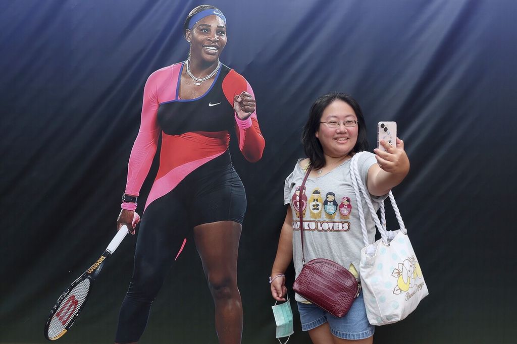 Seorang penggemar melakukan swafoto dengan latar belakang foto petenis putri Serena Williams menjelang Amerika Serikat Terbuka 2022 di Pusat Tenis Nasional Billie Jean King, Flushing Meadows, New York, Minggu (28/8/2022).