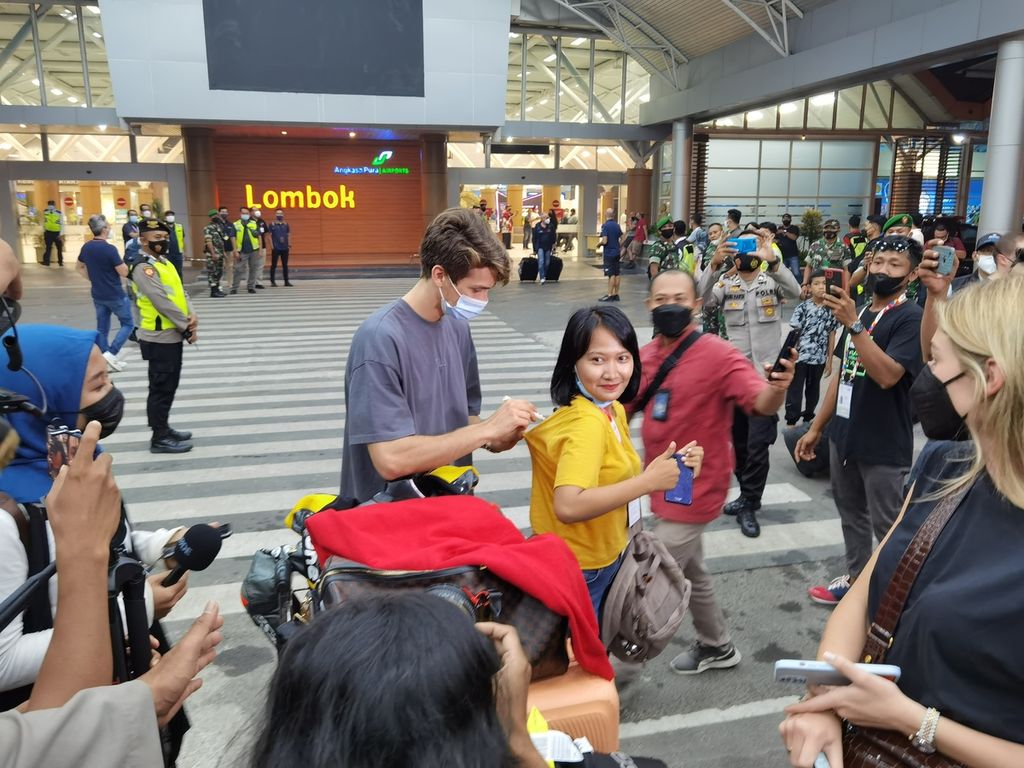 Salah seorang pebalap memberikan tanda tangan ke penggemarnya saat tiba di Bandara Internasional Lombok, Rabu (16/3/2022). Seluruh pebalap yang akan tampil dalam ajang MotoGP, Moto2, Moto3, dan Idemitsu Asia Talent Cup telah tiba di Lombok.
