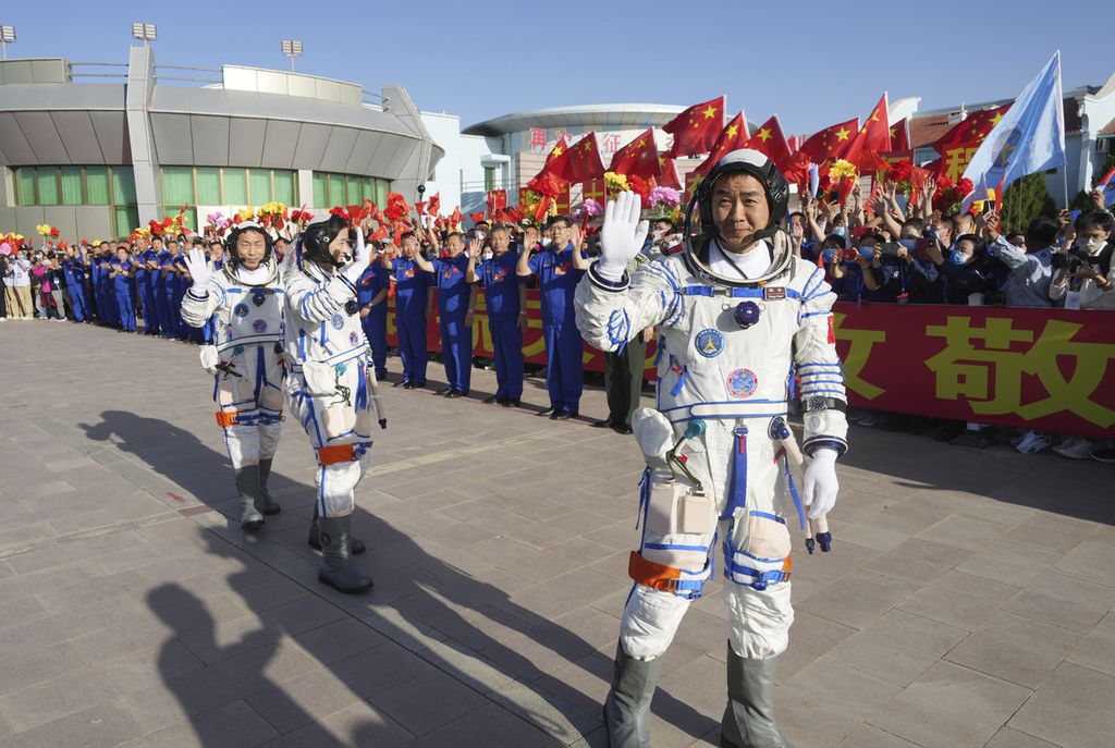 Dalam foto yang dirilis kantor berita China, Xinhua, astronot China, Chen Dong (kanan), melambaikan tangan. Di belakangnya, dua astronot lainnya, Liu Yang dan Cai Xuzhe. Foto diambil pada upacara pelepasan di Pusat Peluncuran Satelit Jiuquan di wilayah China bagian utara, Minggu (5/6/2022).