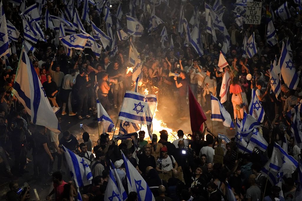 Ratusan ribu warga Israel berunjuk rasa di Tel Aviv, Minggu (26/3/2023), menentang langkah pemerintahan PM Benjamin Netanyahu untuk merombak lembaga peradilan di negara itu. Sekitar 200.000 warga Israel turun ke jalan setelah Netanyahu memecat Menteri Pertahanan Yoav Gallant yang menyatakan penolakan atas perombakan lembaga hukum itu. 