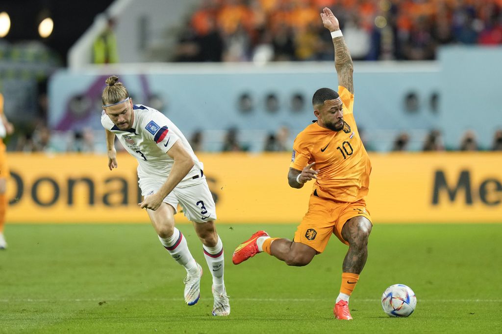 Pemain Amerika Serikat Walker Zimmerman (kiri) dan pemain Belanda Memphis Depay berebut bola dalam pertandingan babak 16 besar Piala Dunia Qatar antara Belanda dan Amerika Serikat di Stadion Internasional Khalifa, Doha, Qatar, Sabtu (3/12/2022). 