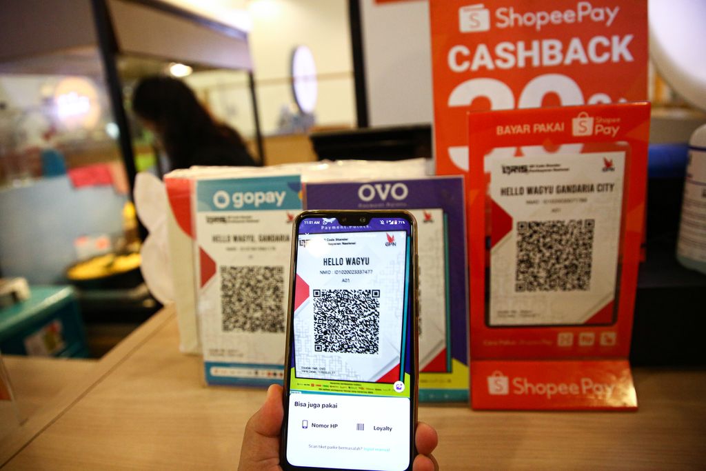 Pengunjung memindai kode QR untuk pembayaran dengan uang elektronik di gerai makanan di pusat perbelanjaan di kawasan Kebayoran Lama, Jakarta Selatan, Senin (2/11/2020). Layanan teknologi finansial di bidang pembayaran semakin populer digunakan terlebih lagi di saat pandemi Covid-19.