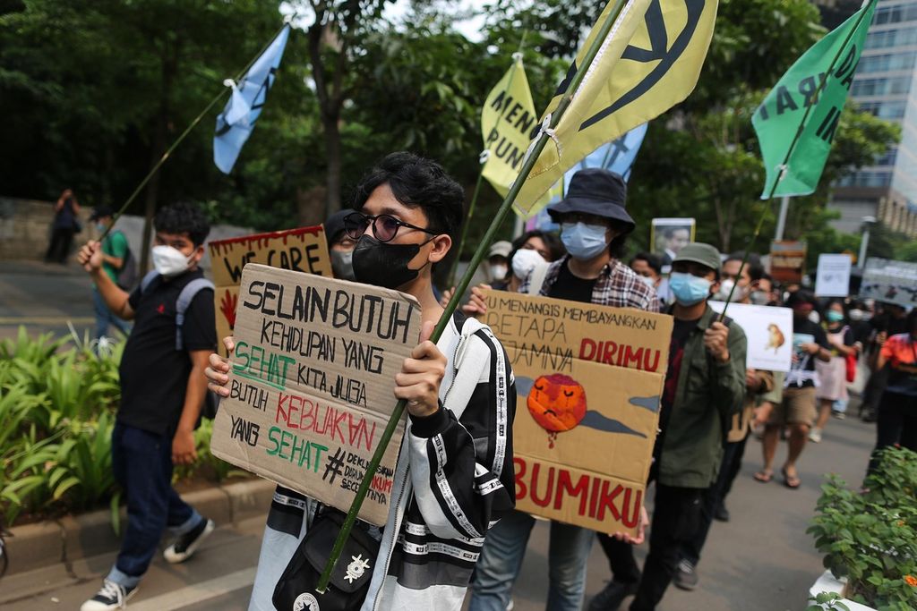 Para aktivis lingkungan menggelar aksi damai menyerukan kedaruratan iklim dalam gerakan Global Climate Strike di kawasan Sudirman, Jakarta, Jumat (25/3/2022). Dalam aksinya, mereka antara lain mendesak pemerintah untuk secara serius melakukan transisi dari energi kotor ke energi bersih. Aksi ini dilakukan secara serentak oleh para aktivis di beberapa kota di Indonesia. 