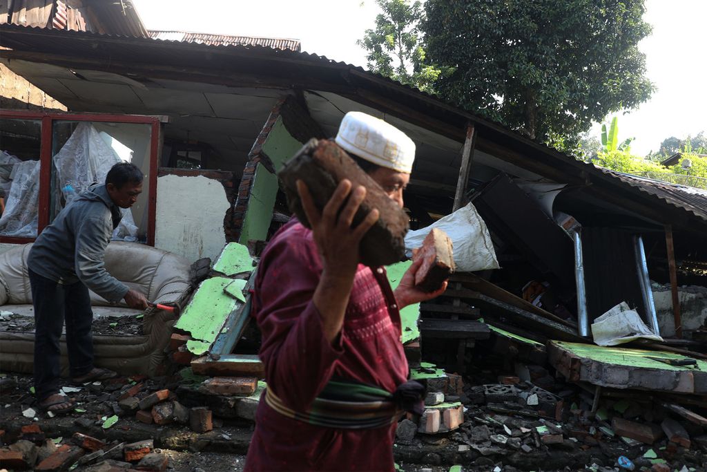Warga dibantu para sukarelawan menyingkirkan puing-puing bangunan yang roboh karena gempa di Nagari Kajai, Kecamatan Talamau, Kabupaten Pasaman Barat, Sumatera Barat, Senin (28/2/2022).