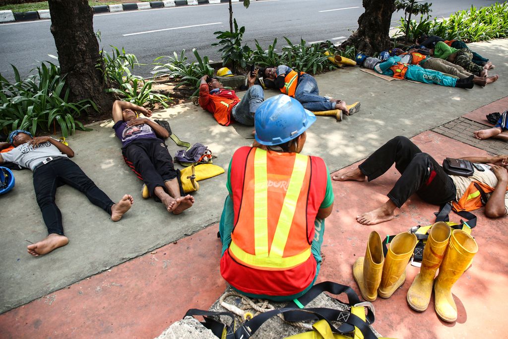 Pekerja proyek properti tidur di trotoar Jalan Casablanca, Jakarta.