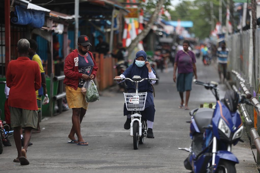 A student with his electric bicycle walks along the stage road that divides Agats City, Asmat, Papua, on his way to school,  onTuesday (12/10/2021).