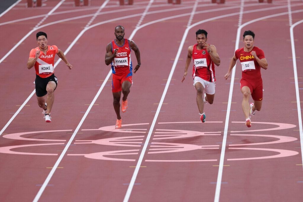 Pelari Jepang, Yuki Koike (kiri); pelari Kepulauan Cayman, Kemar Hyman (kedua dari kiri); pelari Indonesia, Lalu Muhammad Zohri (ketiga dari kiri); dan pelari China, Xinyue Su (kanan); beraksi pada babak <i>heat</i> nomor lari 100m putra Olimpiade Tokyo 2020 di Stadion Olimpiade, Tokyo, Jepang, 31 Juli 2021. 