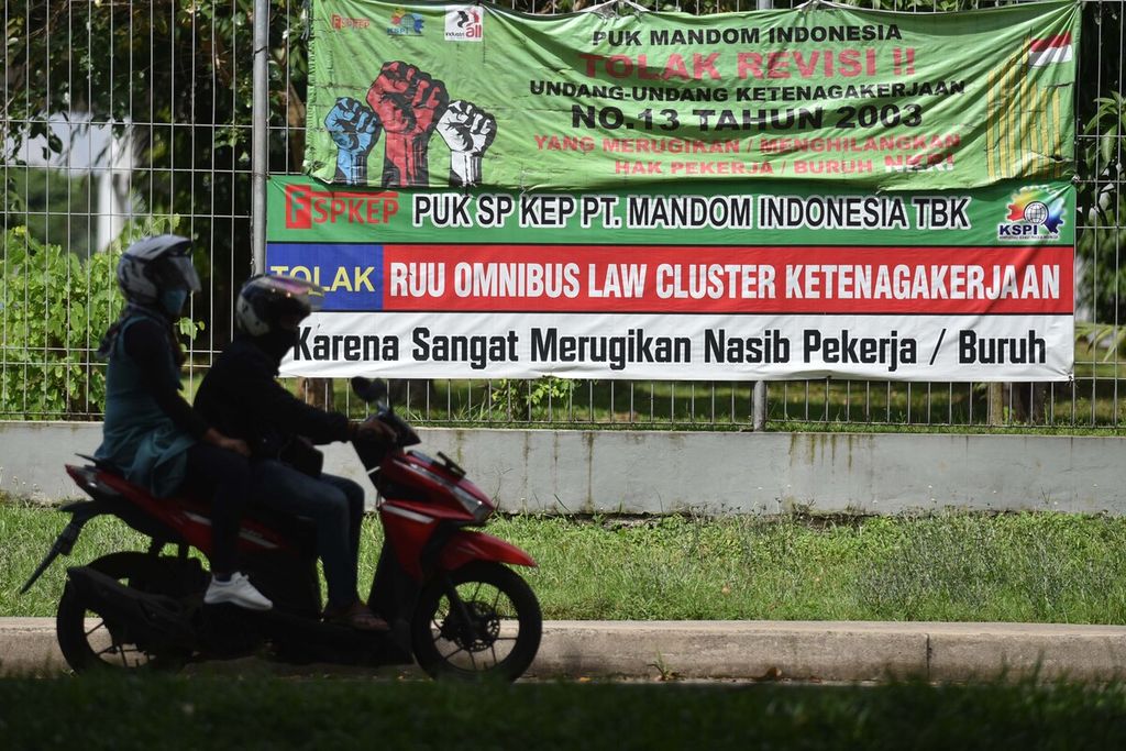 Spanduk penolakan kaum buruh terhadap RUU Ombibus Law Cipta Lapangan Kerja menghiasi Jalan Irian, Jatiwangi, Cikarang Barat, Bekasi, Jawa Barat, Senin (25/5/2020). 