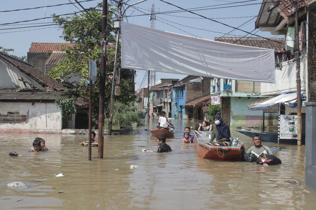 Sejumlah warga melintasi banjir di Desa Dayeuhkolot, Kecamatan Dayeuhkolot, Kabupaten Bandung, Jawa Barat, Selasa (25/5/2021). 