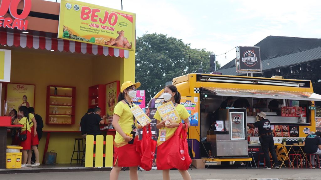 Dua pramuniaga atau <i>sales promotion girl</i> (SPG) berdiri di alun-alun Jakarta Fair Kemayoran, Jakarta Pusat, Sabtu (18/6/2022), untuk mencari calon pembeli.