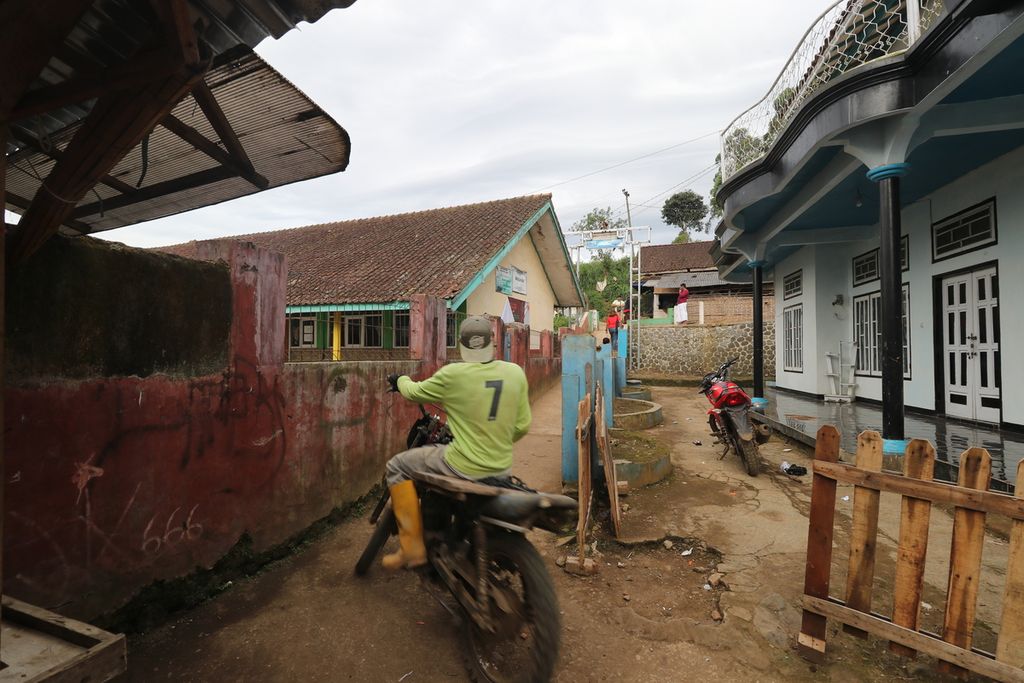 Warga melintasi jalan kecil antar pemukiman di Desa Cikembang, Kecamatan Kertasari, Kabupaten Bandung, Minggu (5/2/2023), Desa Cikembang di hulu Sungai Citarum ini pernah dilanda banjir bandang besar tahun 2021 lalu.