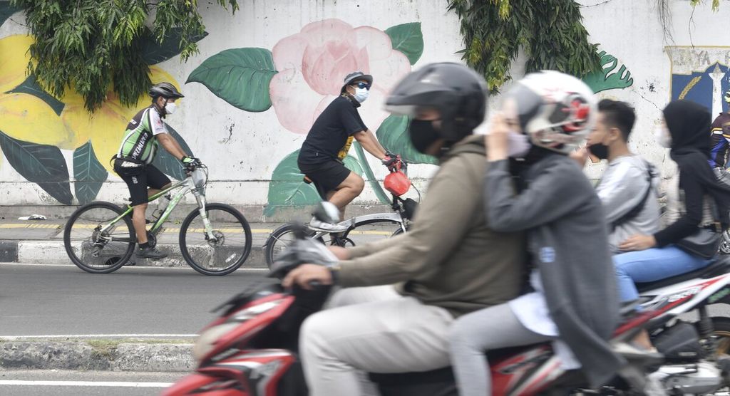 Residents cycle in the Penjaringan area, North Jakarta, Sunday (13/2/2022). This week, PPKM level 3 has been implemented in Jakarta to control the surge in new cases of Covid-19, especially those caused by the Omicron variant. However, residents' discipline to maintain health protocols is still being neglected. 