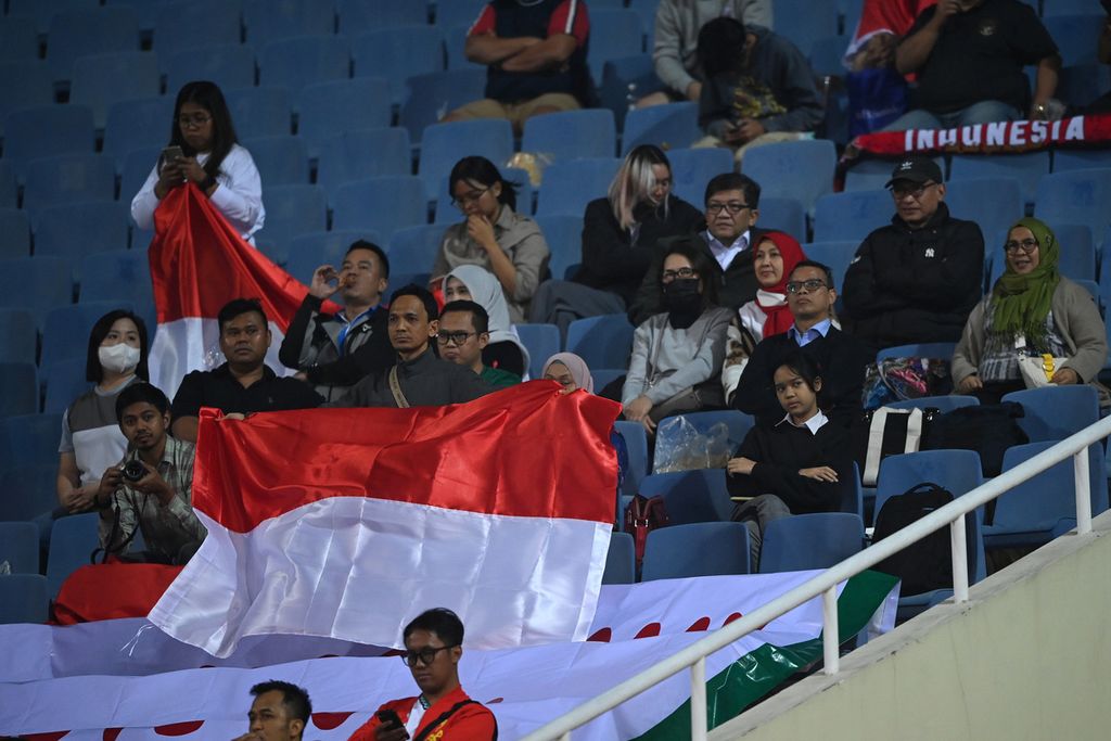 Suporter Indonesia terduduk lesu seusai tim nasionalnya kalah dari Vietnam 0-2 pada pertandingan laga kedua semifinal Piala AFF 2022 di Stadion Nasional My Dinh, Hanoi, Vietnam, Senin (9/1/2023). Langkah Indonesia terhenti di semifinal.